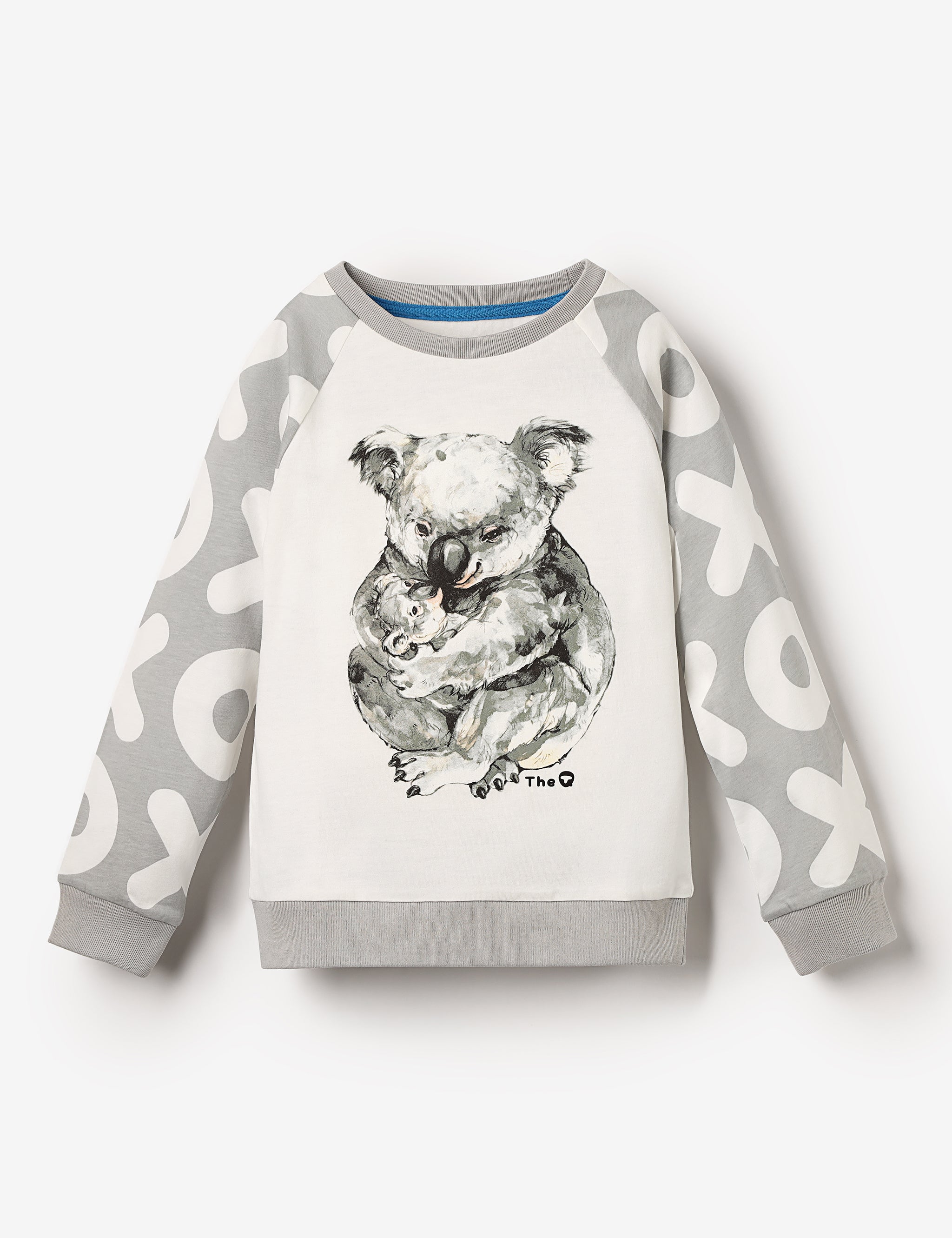 Flat lay of organic cotton kids top with long raglan sleeves and cuddling mama and baby koalas print – unisex, sustainable, plastic-free and stereotype-free.